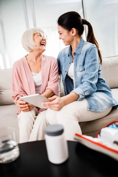 Abuela y nieta usando tableta digital y riendo —  Fotos de Stock