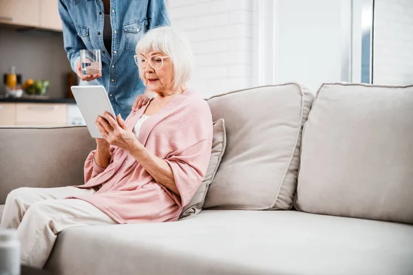 Anciana usando tableta digital mientras pasa tiempo con su nieta —  Fotos de Stock