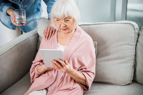 Vieja usando tableta digital mientras pasa tiempo con su nieta — Foto de Stock