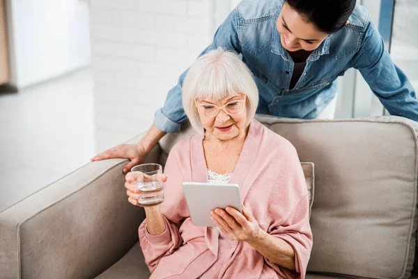 Anciana viendo vídeo en tableta digital con nieta —  Fotos de Stock