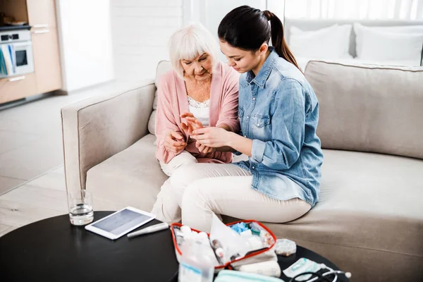 Familie dokter checkt hand van senior dame — Stockfoto