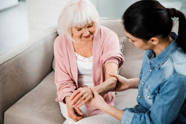 Family doctor holding arm of elderly woman — Stock Photo, Image