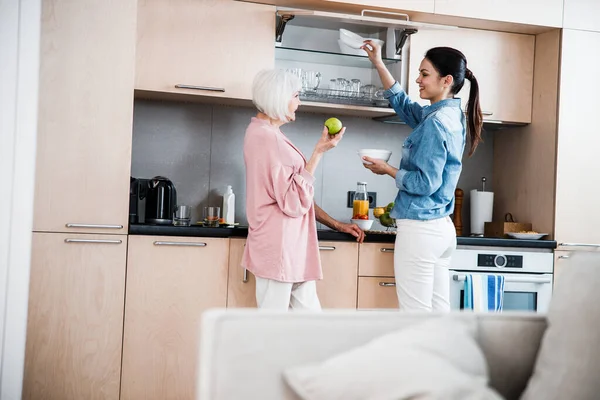 Großmutter und erwachsene Enkelin plaudern in Küche — Stockfoto