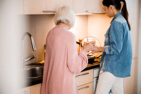 Grandmother and adult granddaughter cooking dinner at home — Stock Photo, Image