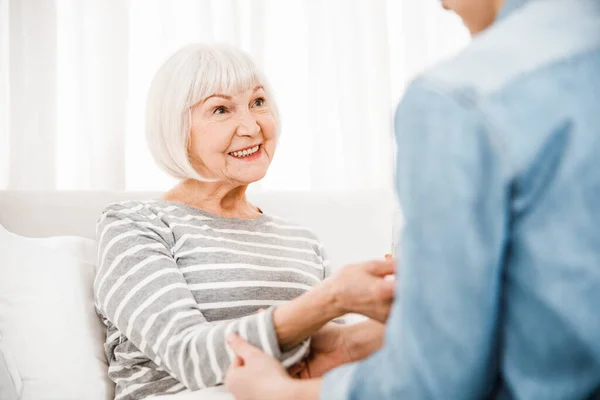 Cheerful elderly woman lying in bed at home — Stock Photo, Image