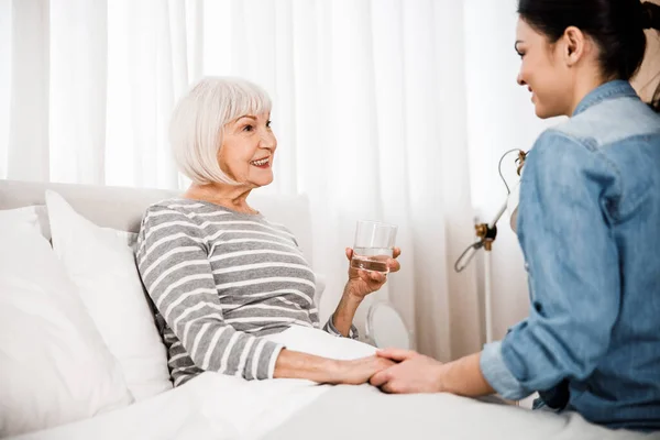 Alegre anciana chateando con su nieta en el dormitorio — Foto de Stock