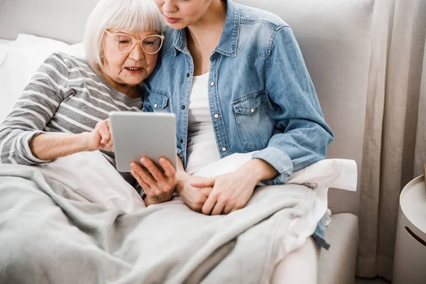 Бабуся і доросла онука використовують сучасний гаджет — стокове фото