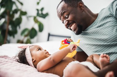 Neşeli baba kızına bakıyor ve gülümsüyor.