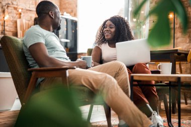 Mutlu Afro-Amerikan çifti evde sohbet ediyor.