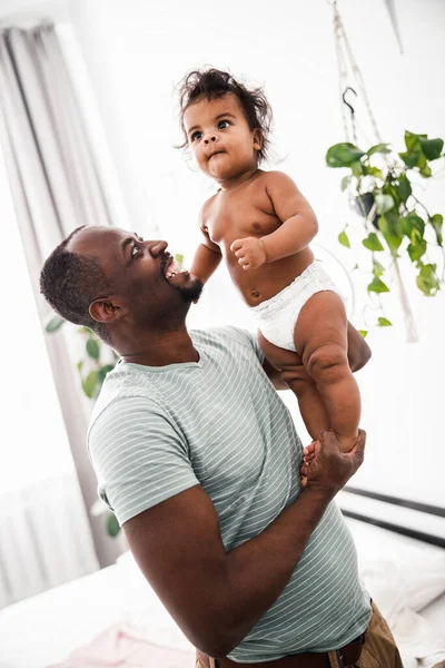 Loving father holding cute newborn daughter and smiling — Stock Photo, Image