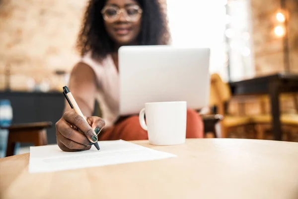 Afro amerikansk kvinna skriver på papper — Stockfoto