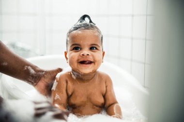 Sevimli Afro-Amerikan bebek banyo yapıyor ve gülümsüyor.
