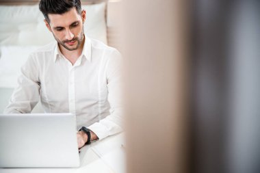 Yatak odasındaki stok fotoğrafında defteri olan bir erkek.