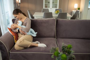 Mutlu bir kadının bebeğini emziren parlak portresi