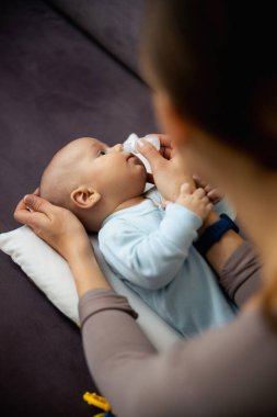 Evdeki küçük çocuğu tedavi eden hanımefendiye yakın durun.