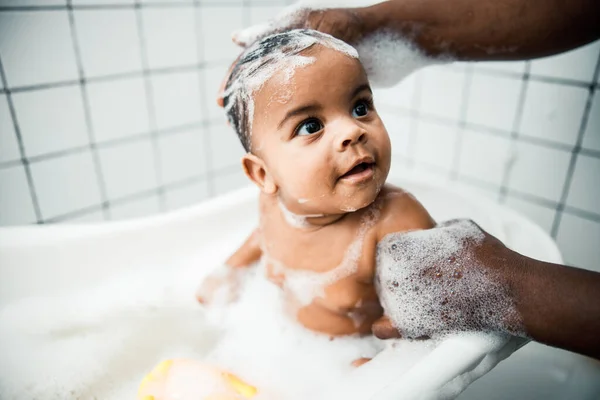 Afro American man washing hair of adorable newborn child — Stock Photo, Image