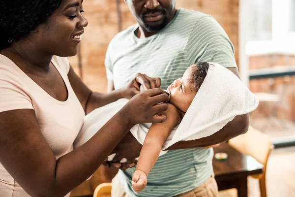 Älskade föräldrar inslagning baby i handduk efter bad — Stockfoto