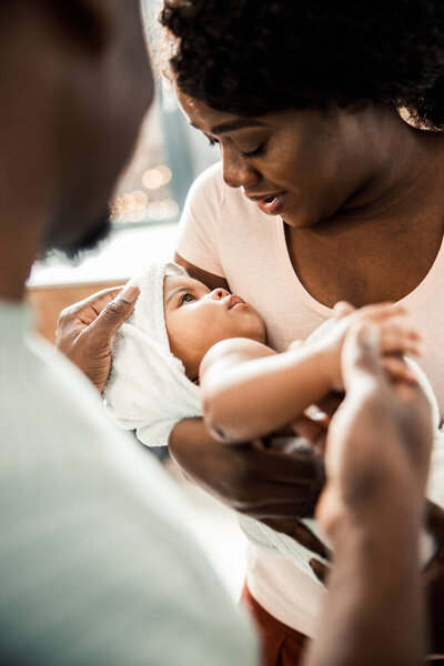 Charming Afro American lady holding baby in her arms
