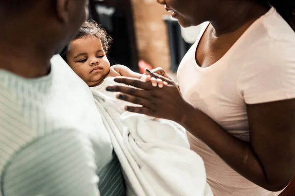 Cute baby wrapped in towel holding mother hand