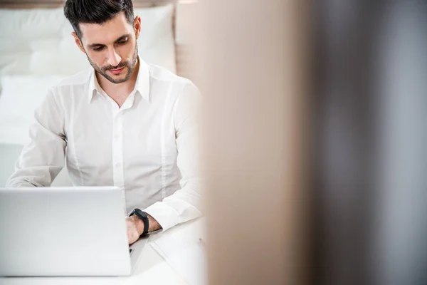 Maschio con notebook in camera da letto stock foto — Foto Stock