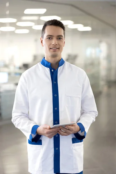 Guapo médico masculino sosteniendo tableta digital y sonriendo — Foto de Stock