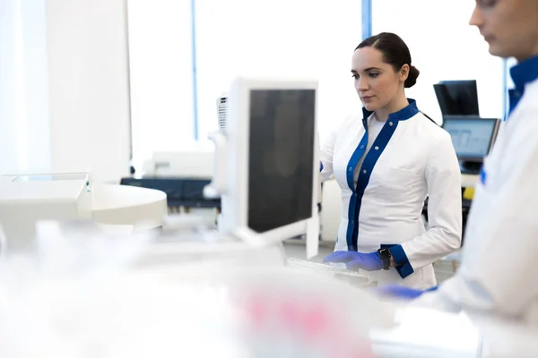 Investigadora en bata de laboratorio trabajando en laboratorio de ciencias — Foto de Stock