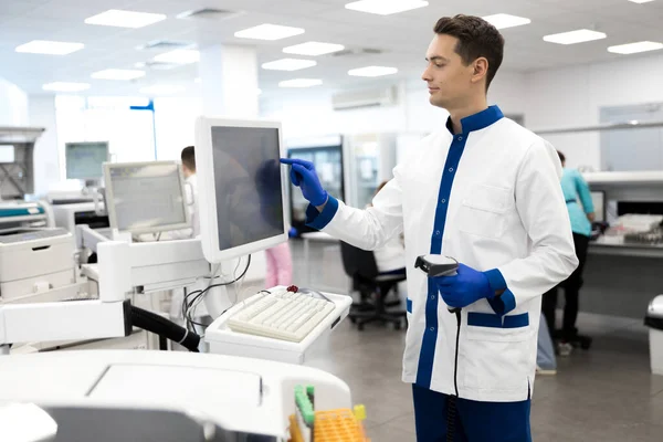Joven científico masculino usando máquina de laboratorio para análisis de sangre de patología — Foto de Stock