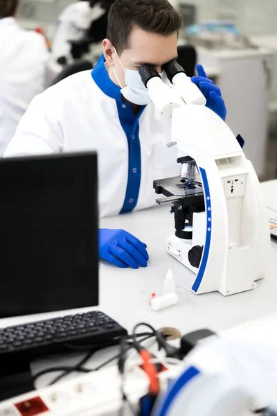 Mannelijke wetenschapper werkt met microscoop in laboratorium — Stockfoto