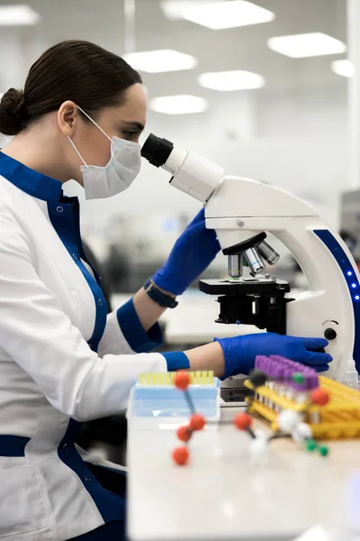 Vrouwelijke wetenschapper werkt met microscoop in laboratorium — Stockfoto