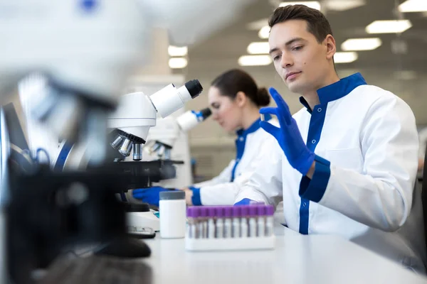 Científicos investigadores que trabajan con microscopios en laboratorio — Foto de Stock