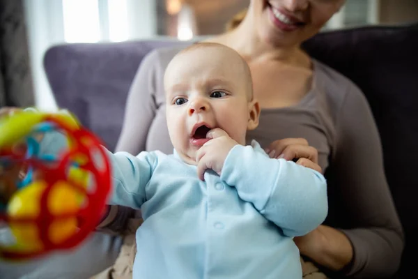 Dame souriante avec son petit bébé jouant sur un canapé au salon — Photo