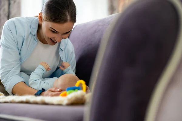 Feliz madre y lindo niño jugando en el sofá en sala de estar — Foto de Stock