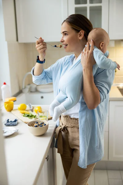 Matka z dzieckiem jedzą jedzenie w domu — Zdjęcie stockowe