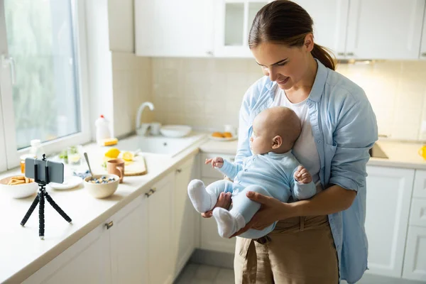 Happy young mother enjoying time with her baby in the kitchen — Stock Photo, Image