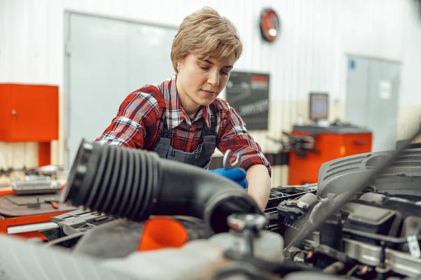 Female mechanic staring at a car engine — Stock Photo, Image