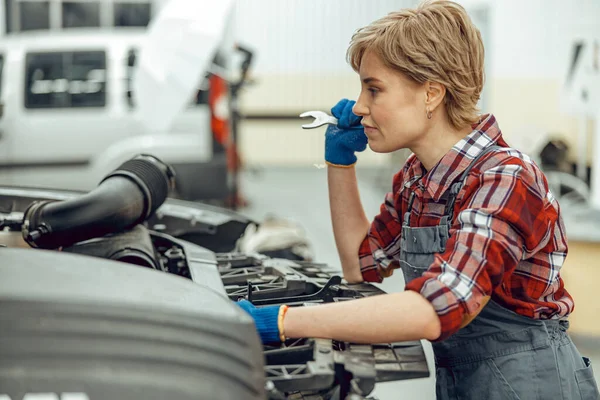 Vrouw met een moersleutel in haar hand — Stockfoto