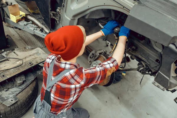 Młody mechanik samochodowy sprawdzający układ hamulcowy — Zdjęcie stockowe