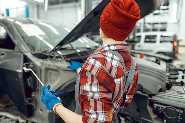 Auto monteur met een moersleutel in haar handen — Stockfoto