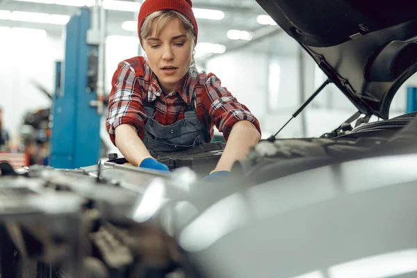 Gerichte vrouwelijke monteur controleren van een auto motor — Stockfoto