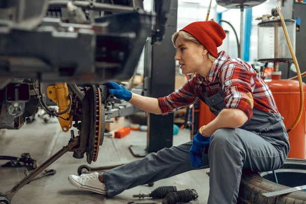 Jonge monteur zittend op een autoband — Stockfoto