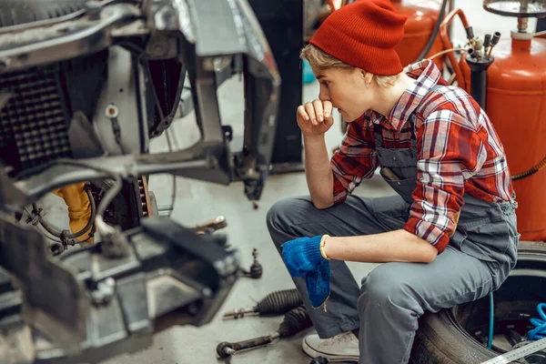 Allvarlig kvinnlig mekaniker som diagnostiserar ett bilproblem — Stockfoto