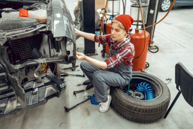 Cetvel kullanan çalışkan genç bir kadın tamirci.