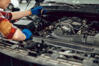 Tamirci yağ tankından çubuğu çıkartıyor.