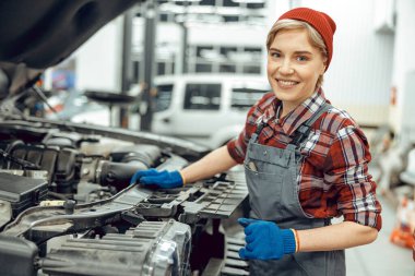 Kameraya poz veren neşeli sevimli bir teknisyen.