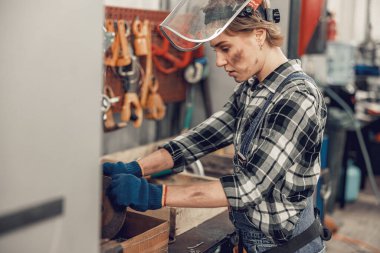 Benzin istasyonunda çalışan odaklanmış bir kadın.