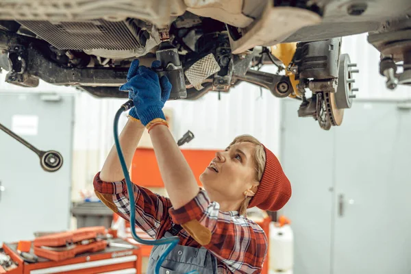 Mujer joven sosteniendo una llave inglesa de impacto aéreo — Foto de Stock