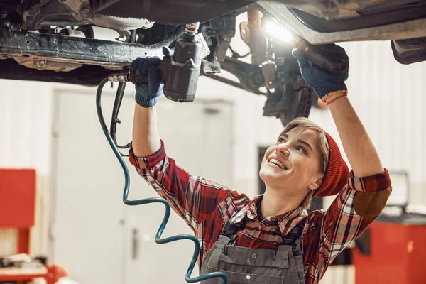 Woman holding a flashlight and an impact wrench