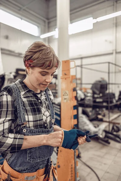 Βρώμικη γυναίκα μηχανικός που βγάζει προστατευτικά γάντια — Φωτογραφία Αρχείου