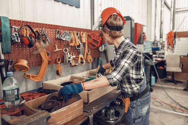Vrouw in een helm en handschoenen die binnen werken — Stockfoto
