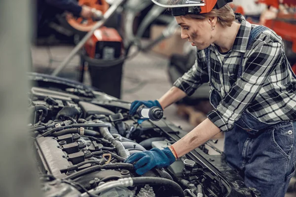 Técnico automotriz profesional inclinado sobre un vehículo — Foto de Stock